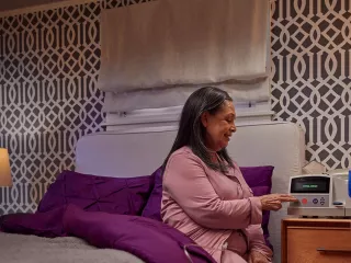Woman sitting on the side of the bed and tabs button on monitor